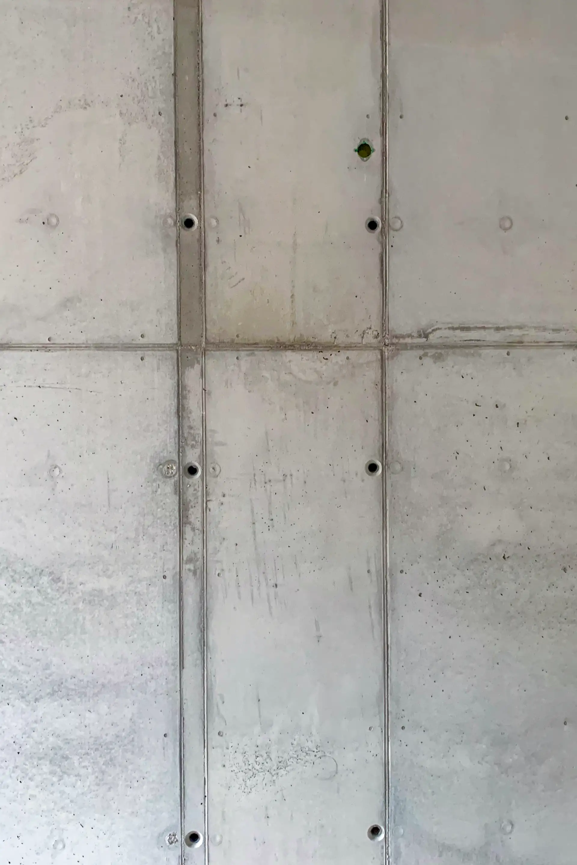 Sichtbetonwand im Rohzustand ohne Ankerkonen – sichtbare Bohr- und Ankerstellen.